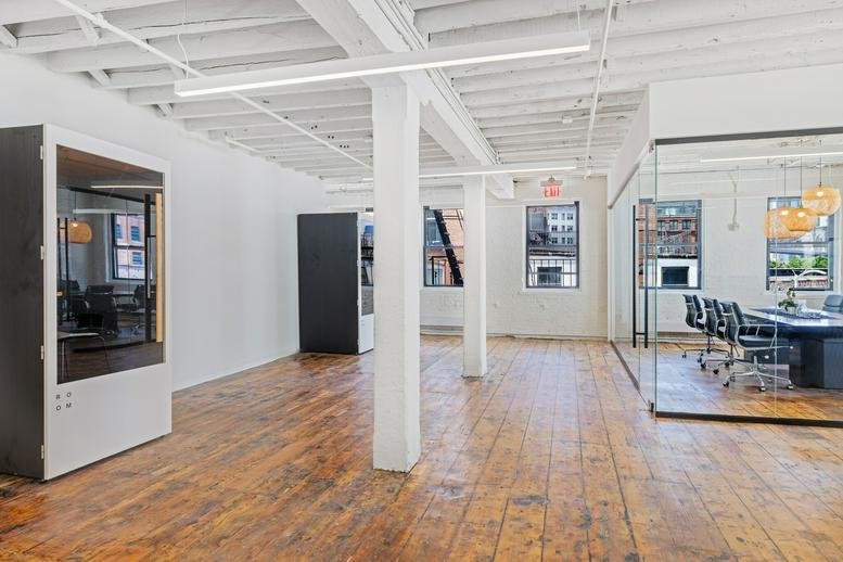 Spacious open-plan office at 53 Pearl Street, Dumbo, Brooklyn, New York with wood floors and glass-walled meeting room.