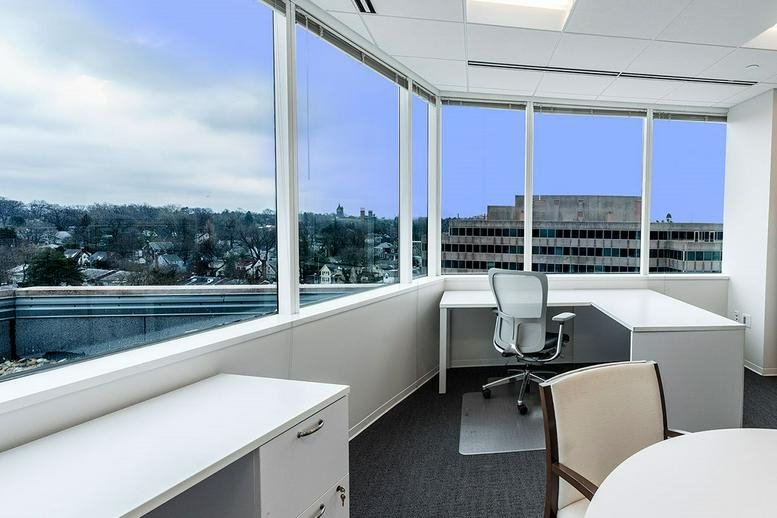 Corner office at 5335 Wisconsin Avenue NW with large windows and a panoramic city view.