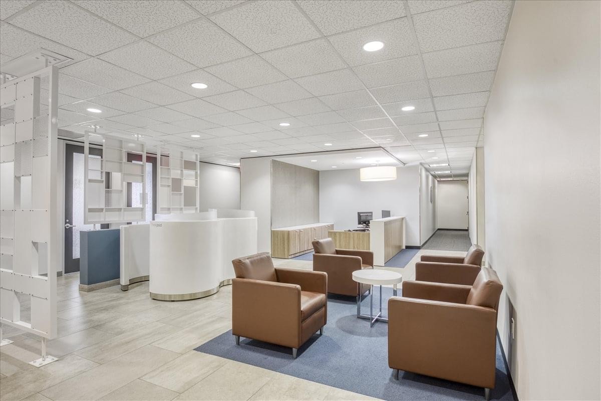 Modern lobby and lounge area at Westheimer Business Center with leather armchairs and white reception pods.