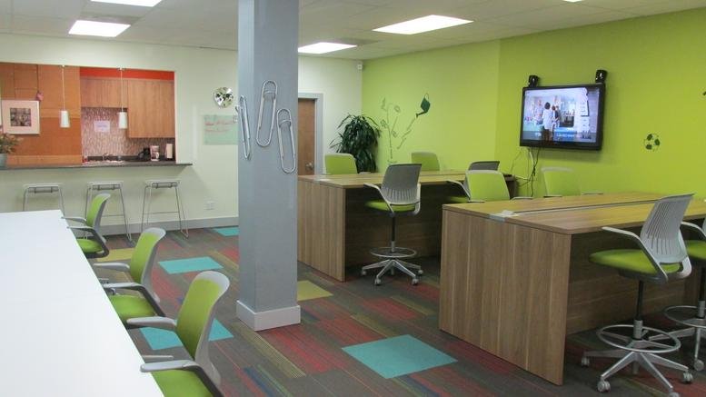 Colorful coworking area at 5460 Babcock Road, Suite 120C, with lime green walls and modern workstations.