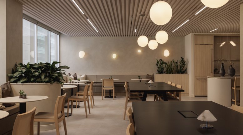 Spacious communal lounge at 550 6 Avenue Southwest featuring slatted wood ceilings and warm pendant lighting.