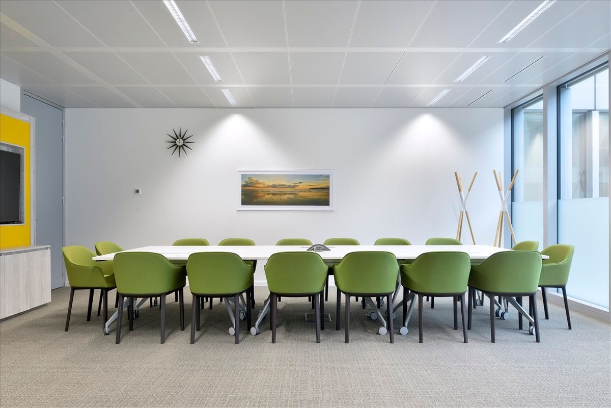 Meeting room at 5501 La Branch St, Suite 13 with lime green chairs and a long white table.