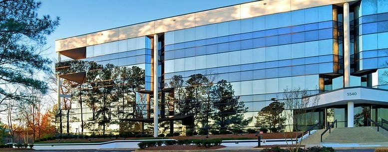 Modern glass exterior of the office building at 5540 Centerview Drive, Suite 200.