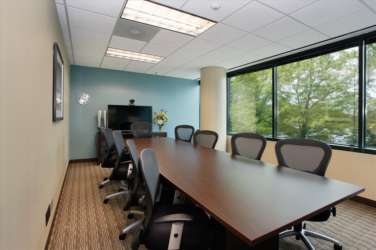 Conference room at 555 Marriott Drive, Suite 315, featuring a large wooden table and views of green trees.