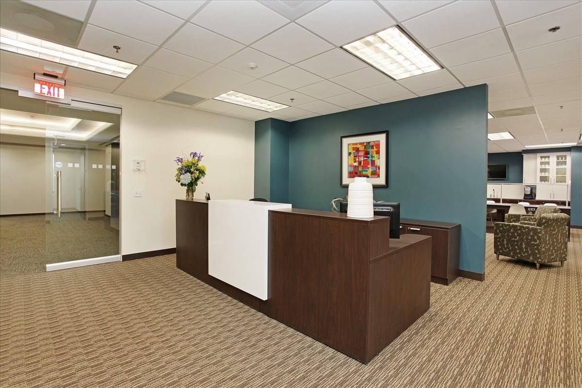 Reception area at 555 Marriott Drive, Suite 315 featuring a dark wood front desk and teal accent wall.