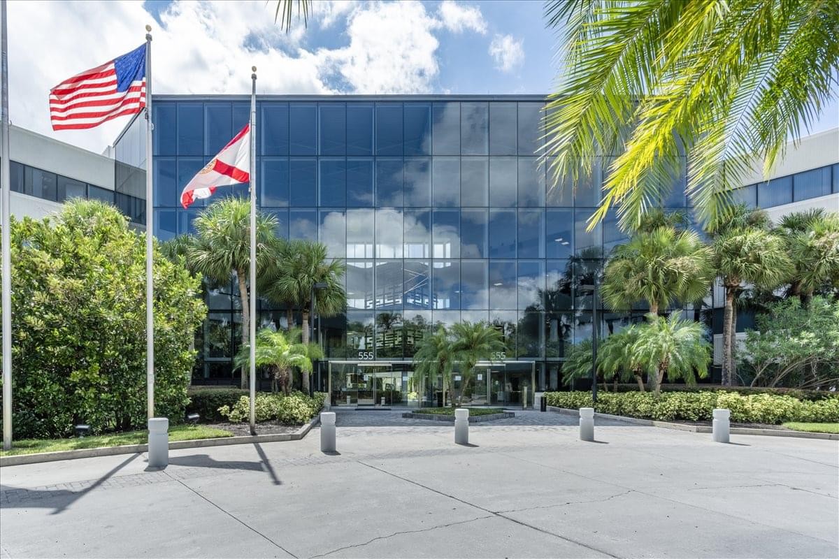 Exterior view of the glass-facade building at 555 Winderley Place, Suite 300.