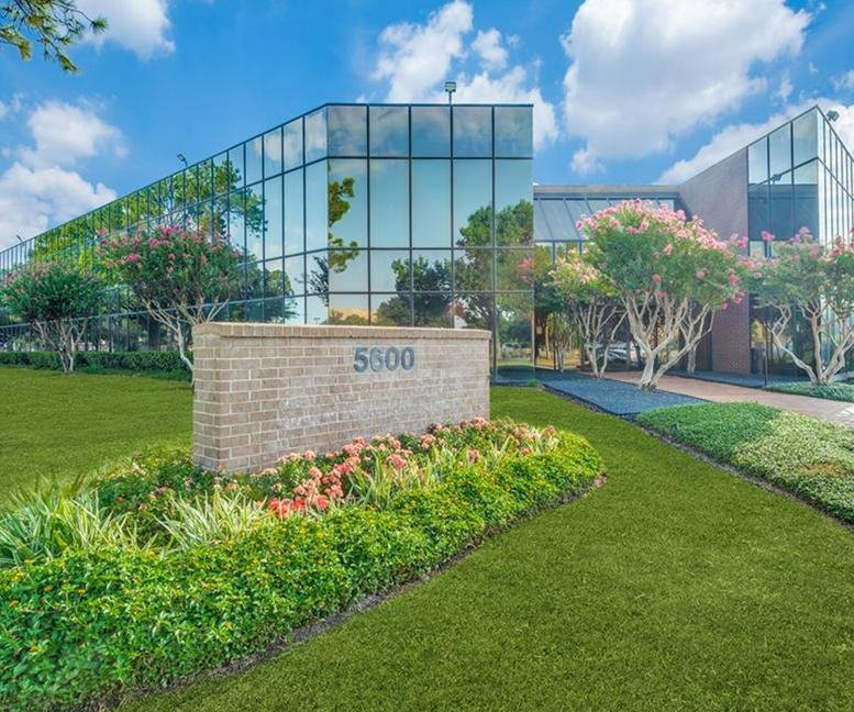 Exterior of the modern glass-fronted office building at 5600 Northwest Central Drive.