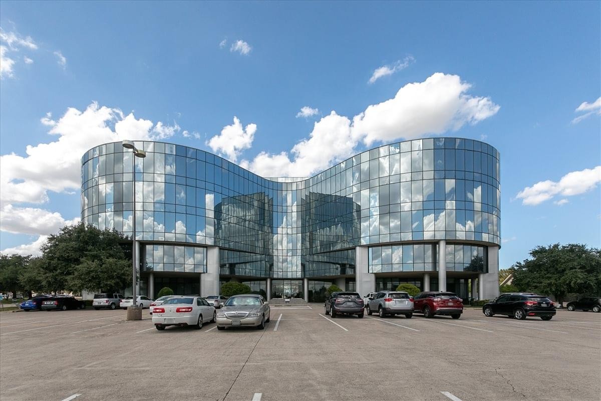 Exterior view of the curved glass facade at 5601 Bridge Street, Suite 300.