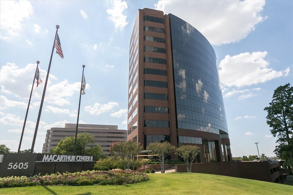 Exterior view of the glass and brick facade of Las Colinas MacArthur at 5605 North MacArthur Boulevard.