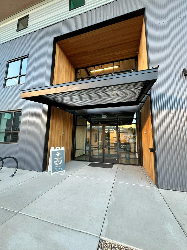 Exterior entrance of the modern industrial-style building at Work-Collective Midway.