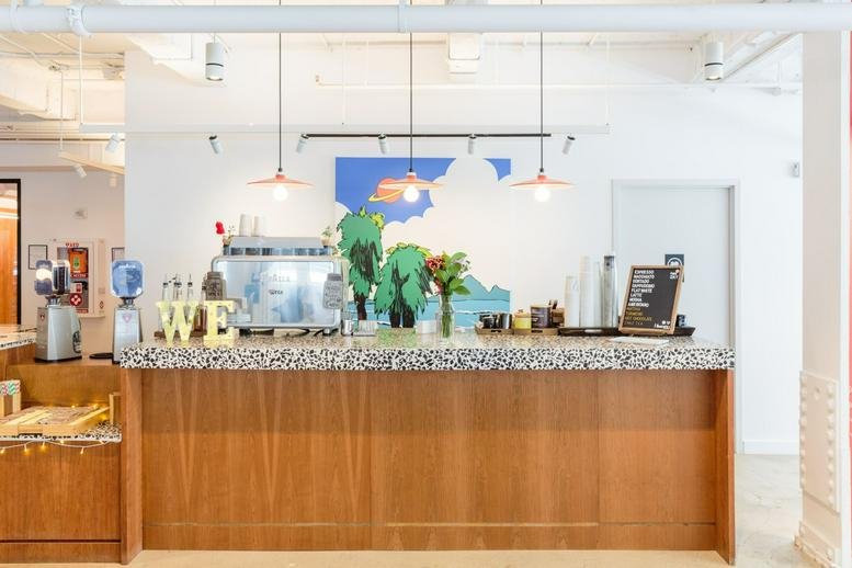 Reception desk at 575 Lexington Avenue with a stone countertop and colorful wall mural.