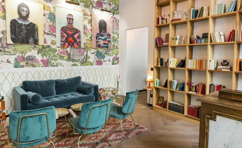 Reception and lobby area at 575 Market St, San Francisco, California featuring velvet seating and floor-to-ceiling bookshelves.
