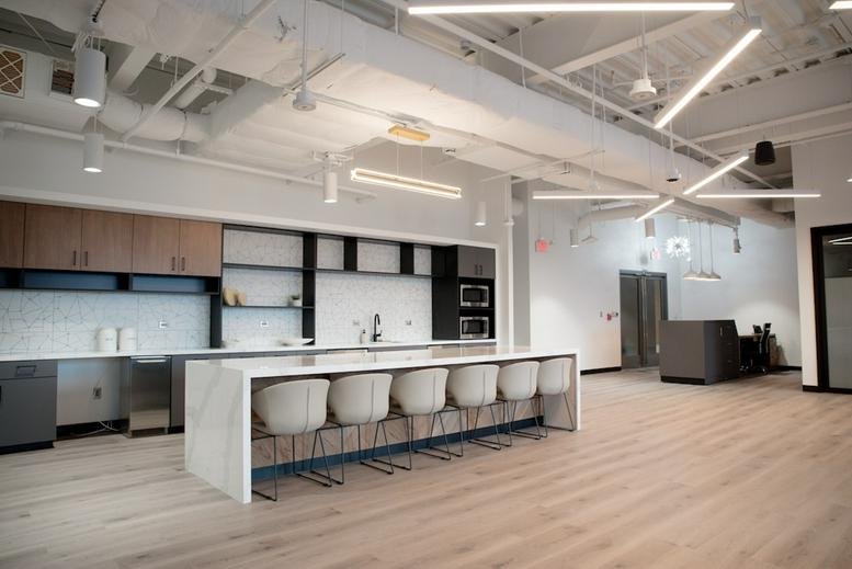 Modern kitchen and cafe area with a large marble island and bar seating.