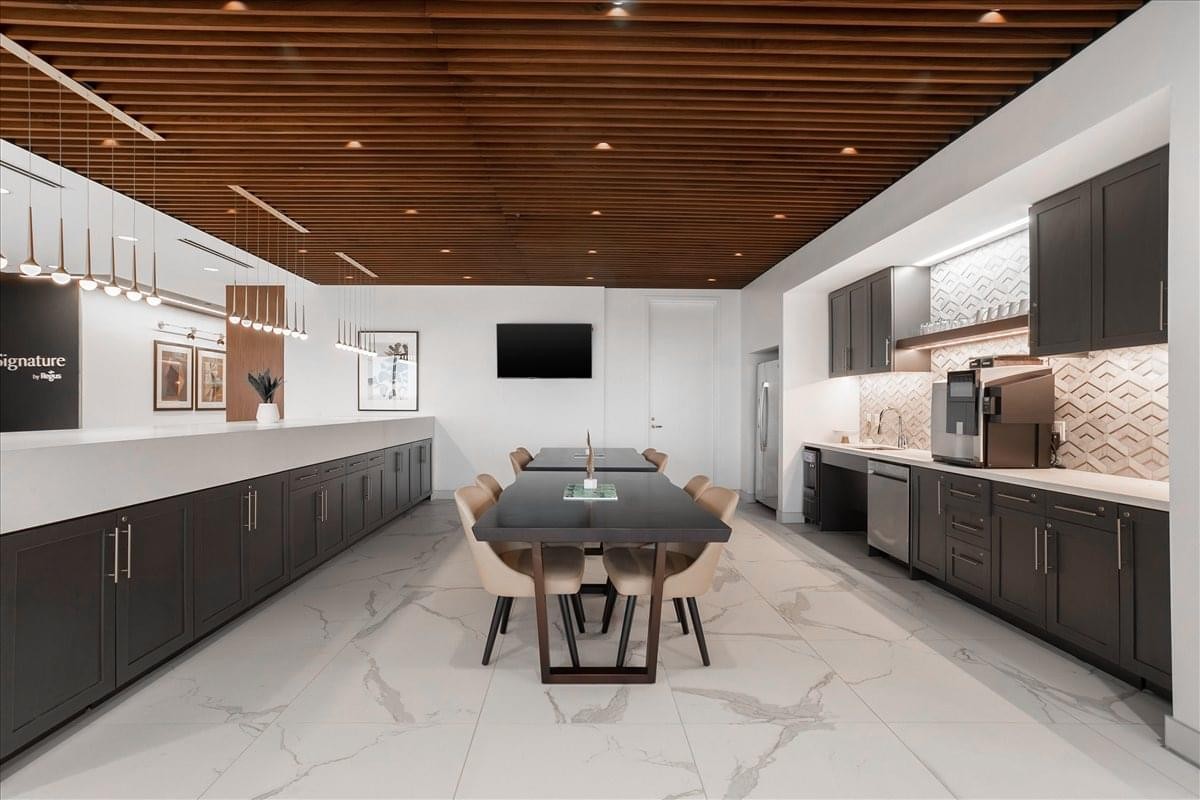 Communal dining area at 5956 Sherry Lane, Suite 1000, with wood-slat ceilings and marble flooring.