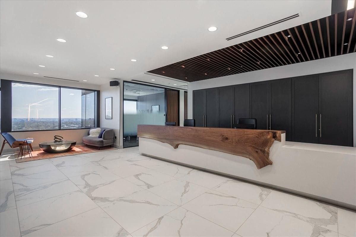 Reception area at 5956 Sherry Lane, Suite 1000 featuring a live-edge wood front desk and marble floors.
