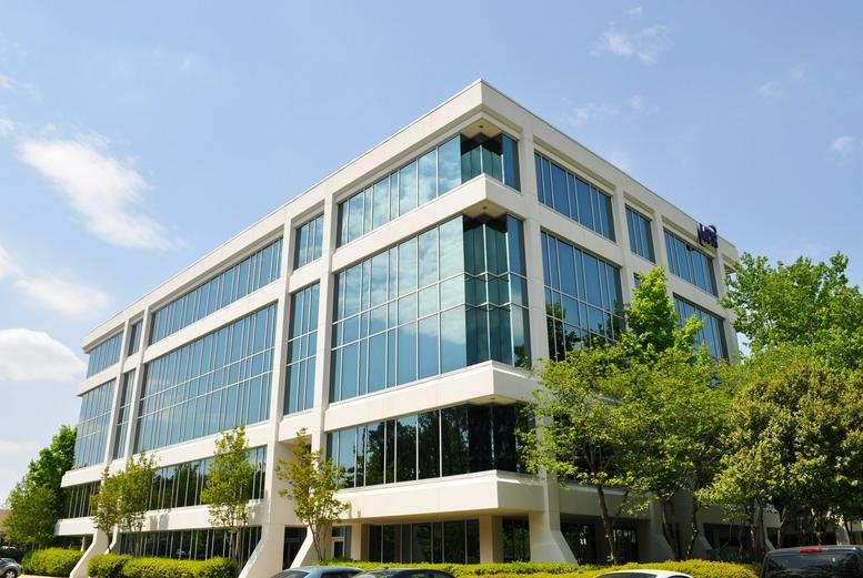 Full view of the multi-story professional building with glass windows and white framing.