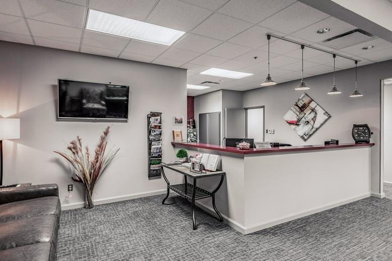 Professional reception area with white front desk and modern pendant lighting.