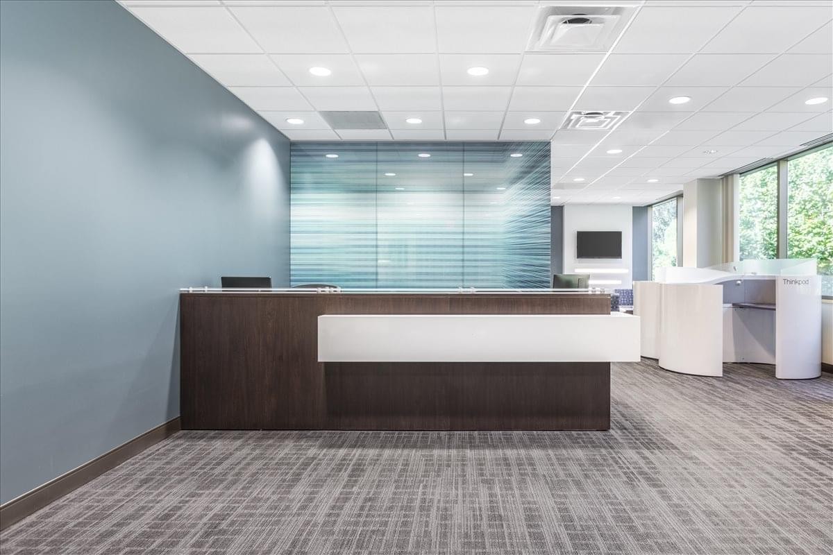 Bright reception area at 600 Eagleview Blvd. with a dark wood desk and frosted glass wall.