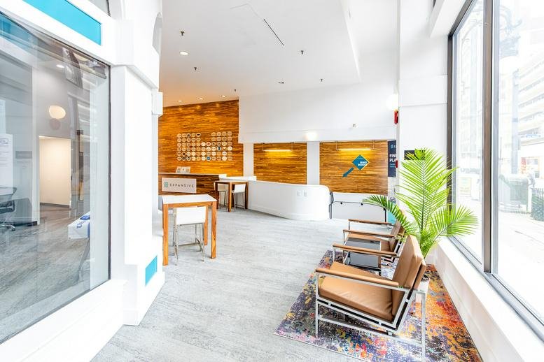 Lobby area with wood-paneled walls, white reception desk, and leather armchairs.