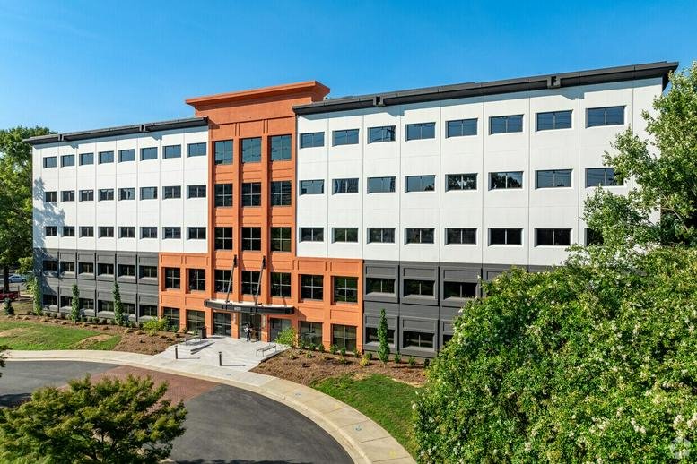 Exterior view of the multi-story brick and white facade at 6135 Park South Drive.