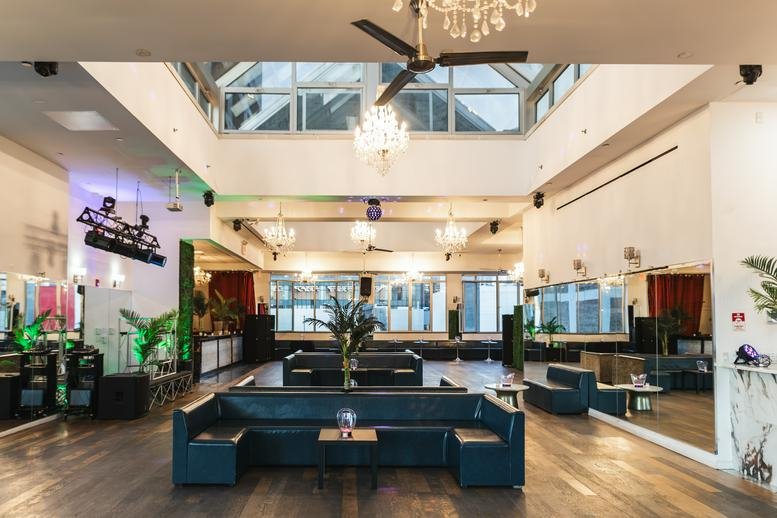 Spacious main event hall at The Penthouse, 617 West 46th Street, Manhattan, New York City with skylights and chandeliers.