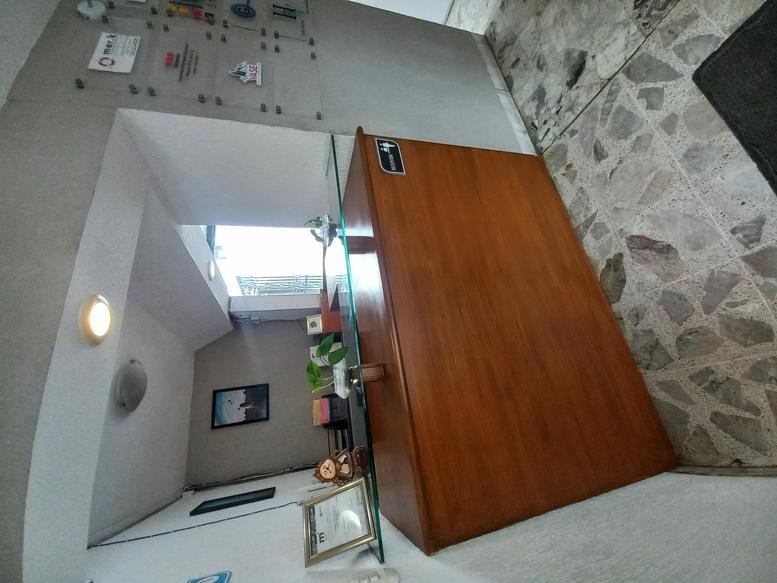 Reception area at Business Center, Colonia Providencia, Morelia featuring a wooden desk and framed certificates.