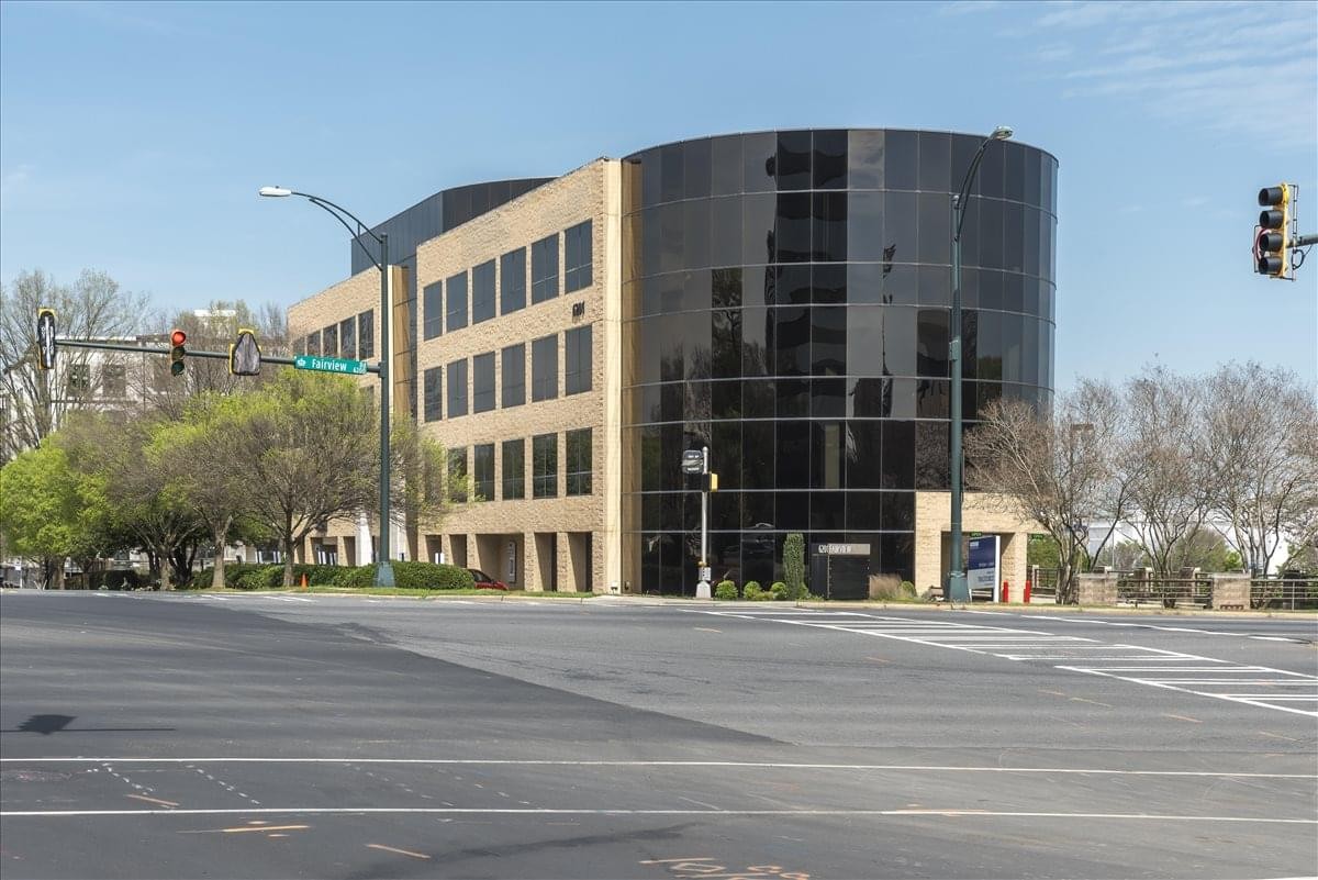 Exterior view of the modern glass and stone building at 6201 Fairview Road.