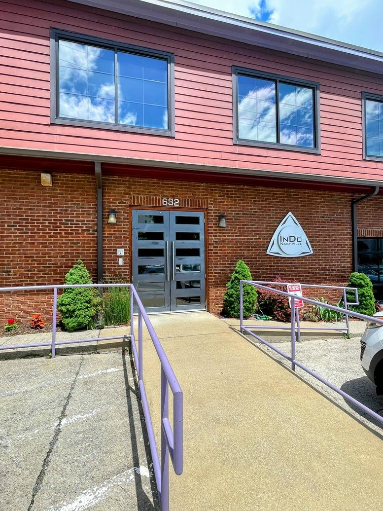 Exterior brick building entrance of InDo Nashville at 632 Fogg Street with purple railings.