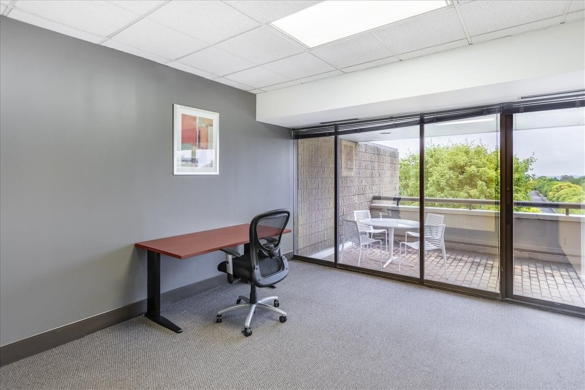 Internal office at Foster Plaza Center with a desk, ergonomic chair, and floor-to-ceiling windows.