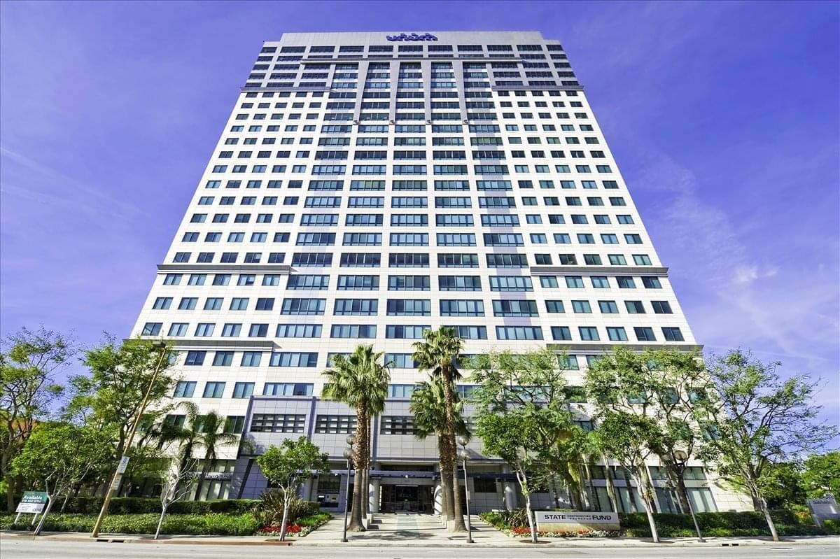 Exterior view of the Glendale Plaza high-rise building against a bright blue sky.