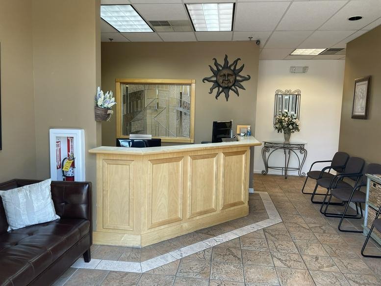 Bright reception area at The Marketplace at Huntingdon Valley, Buck Road with a wooden desk and sun wall art.