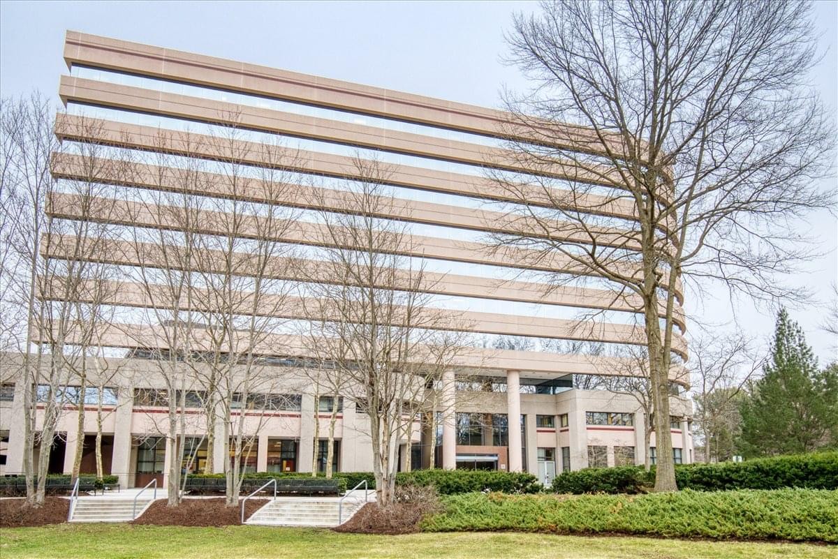 Exterior facade of 6701 Democracy Boulevard Center with distinctive horizontal window bands and mature trees.