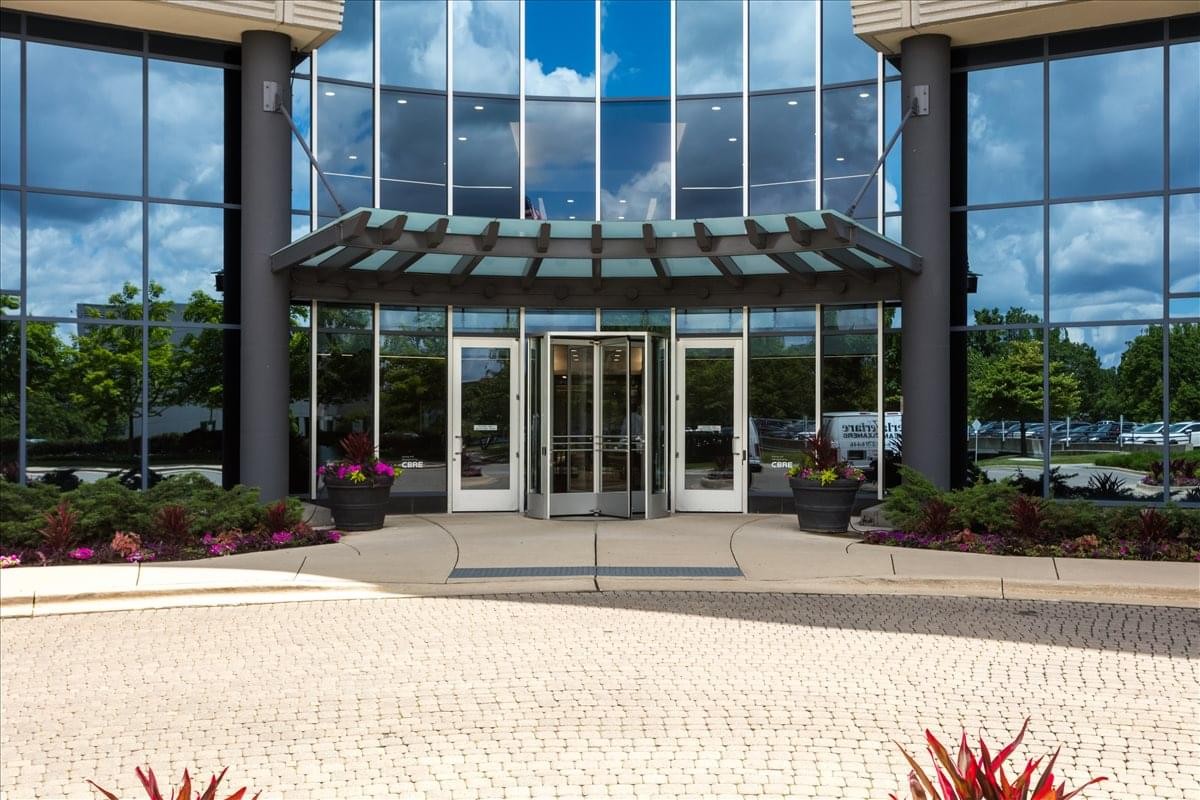 Exterior entrance of Oak Brook Pointe featuring a glass facade and covered revolving doors.