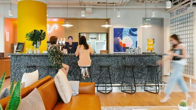 Spacious reception and cafe area at 700 K Street Northwest with a marble-textured bar and yellow accent pillar.