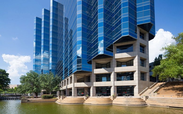 Exterior view of the blue glass tiered facade at 7000 Central Parkway beside a pond.