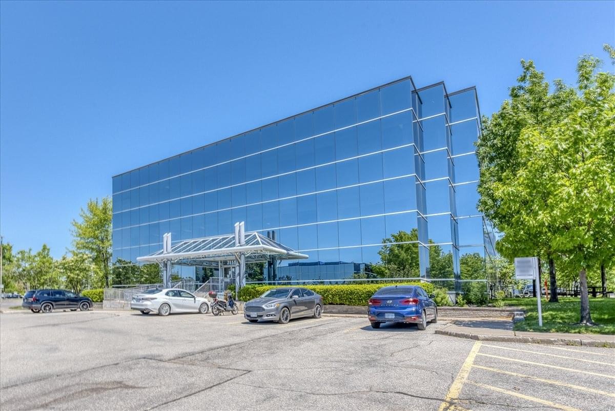 Exterior view of the multi-story glass-facade building at 7111 Syntex Drive.