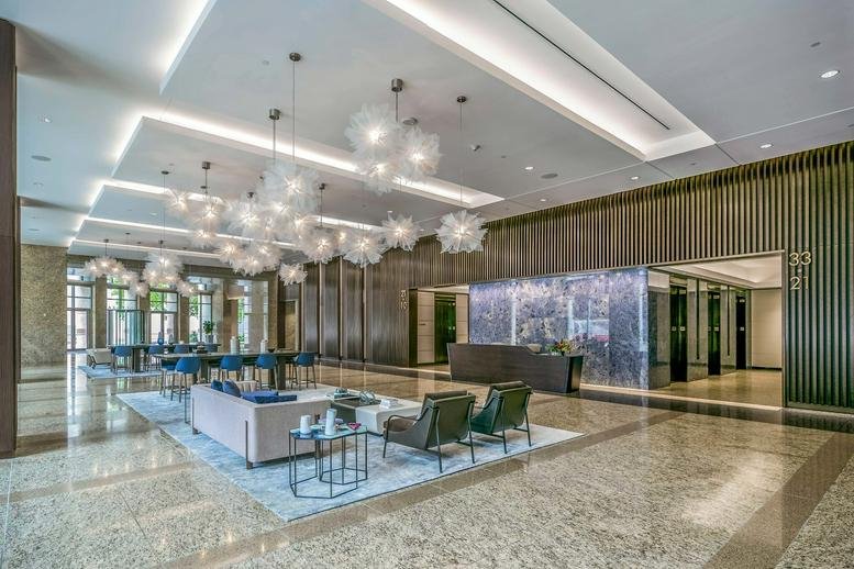 Modern lobby at 717 Texas Avenue featuring marble floors and unique cloud-like chandeliers.