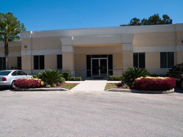 Main entrance facade of 7320 East Fletcher Avenue with manicured landscaping and a clear blue sky.