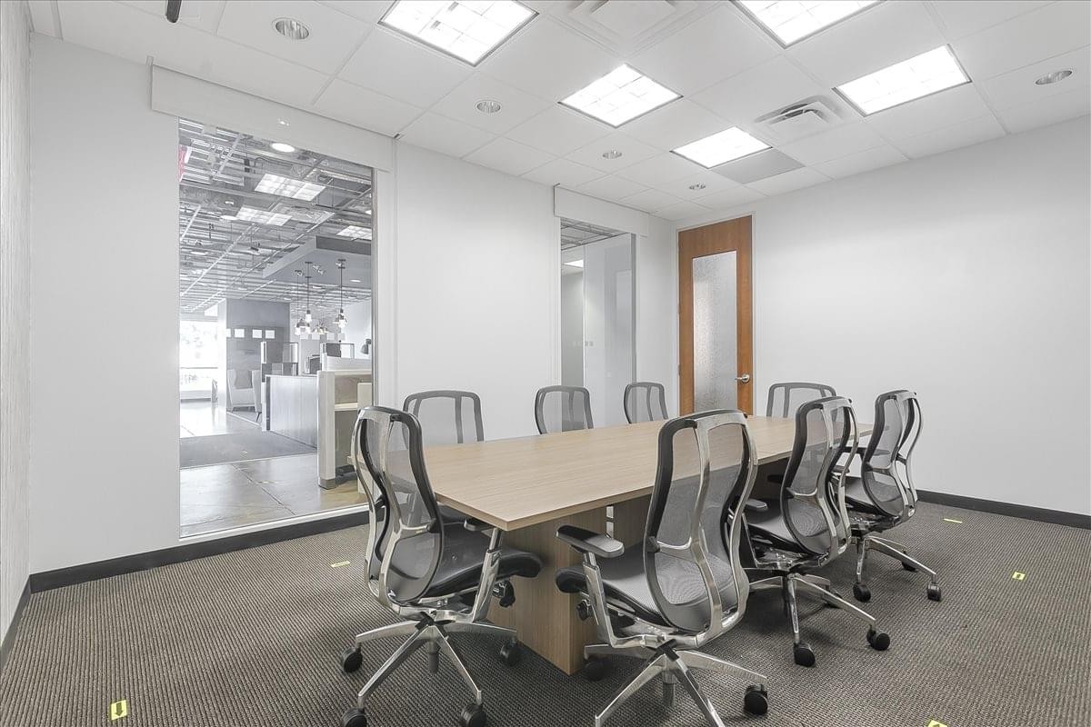 Spacious meeting room with a wooden table and glass wall at 7460 Warren Parkway, Suite 100, Stonebriar Center.