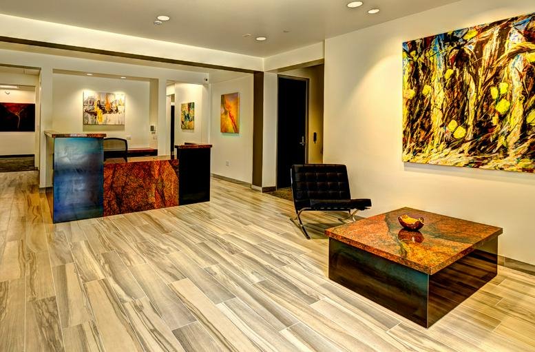 Reception area at 74710 Hwy 111, Ste 102 featuring a stone desk and abstract art.