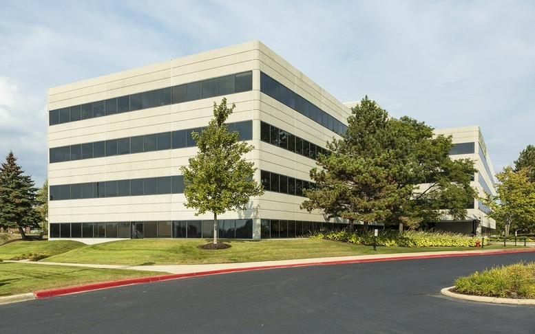 Exterior facade of the multi-story 75 Executive Drive, Aurora (Illinois) building surrounded by green lawn.