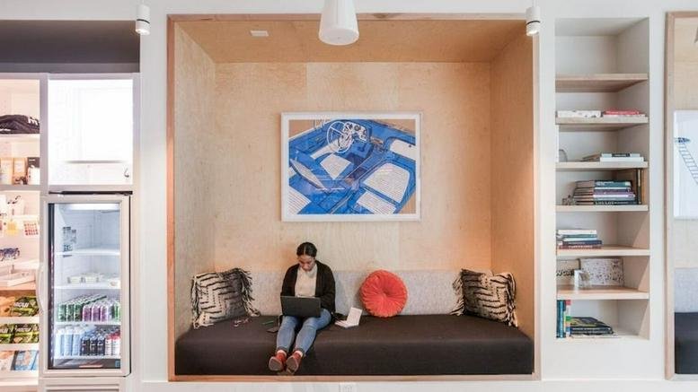 A person works on a laptop in a cozy wooden recessed seating nook at 756 W Peachtree St NW.