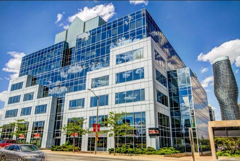 Exterior view of the multi-tiered glass and stone facade at 77 City Centre Drive.