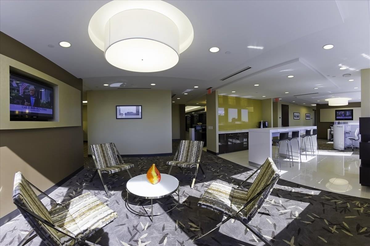 Communal lounge with stylish striped armchairs, a coffee table, and flat-screen TV.
