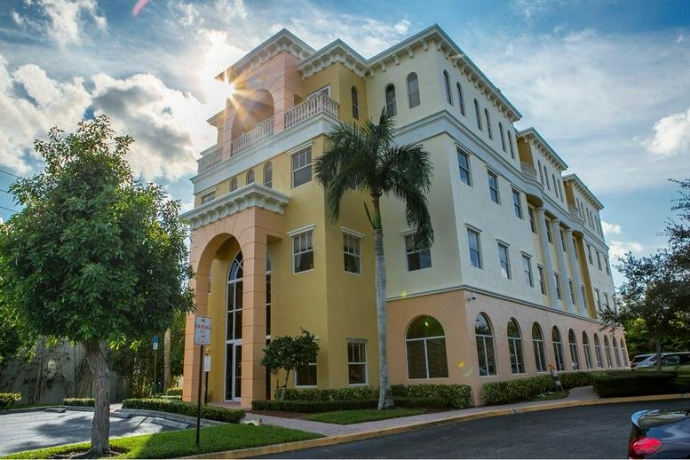 Exterior view of the Mediterranean-style building at 7999 N Federal Highway, 4th Floor, Boca Raton, Florida.