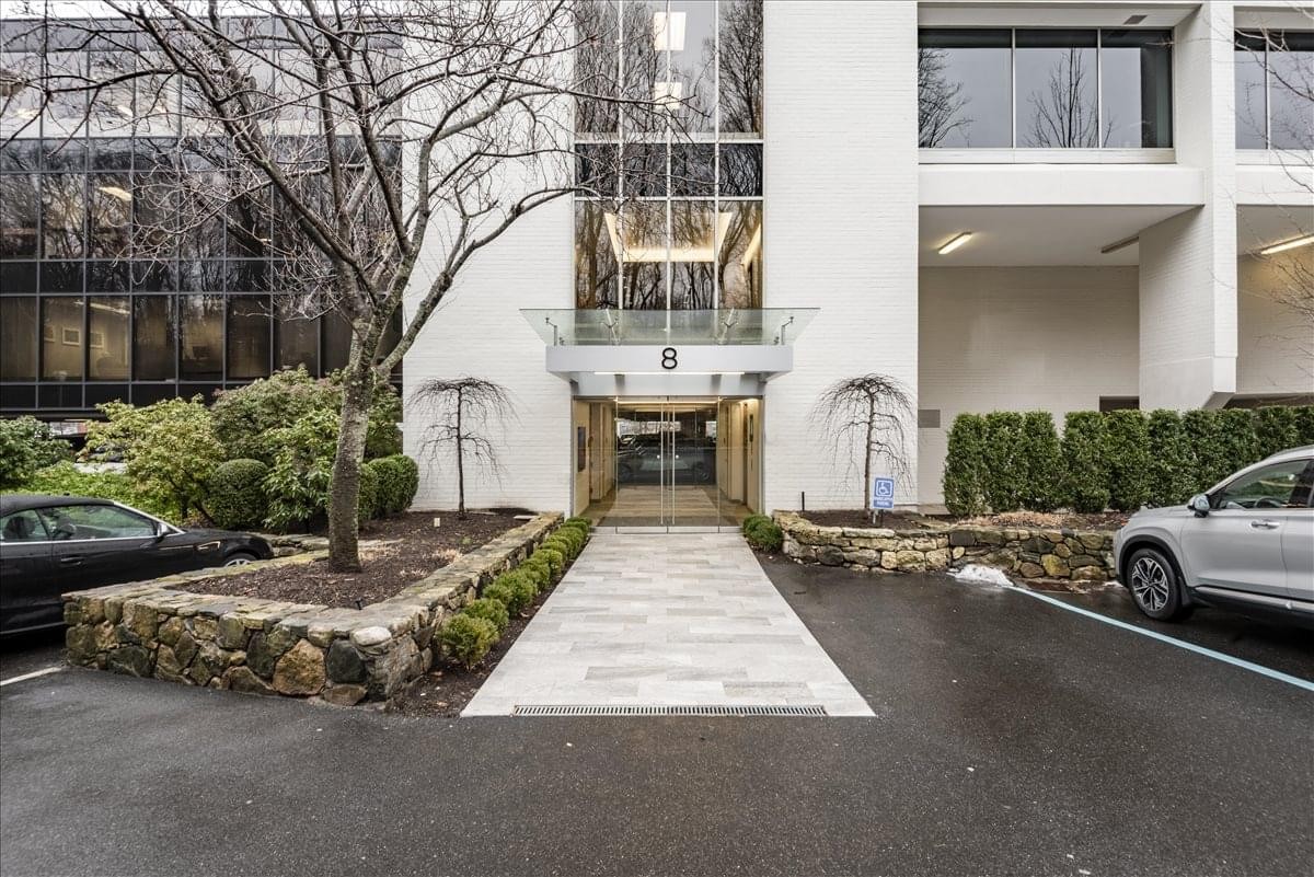 Exterior entrance of 8 Wright Street featuring a stone-lined walkway and glass facade.