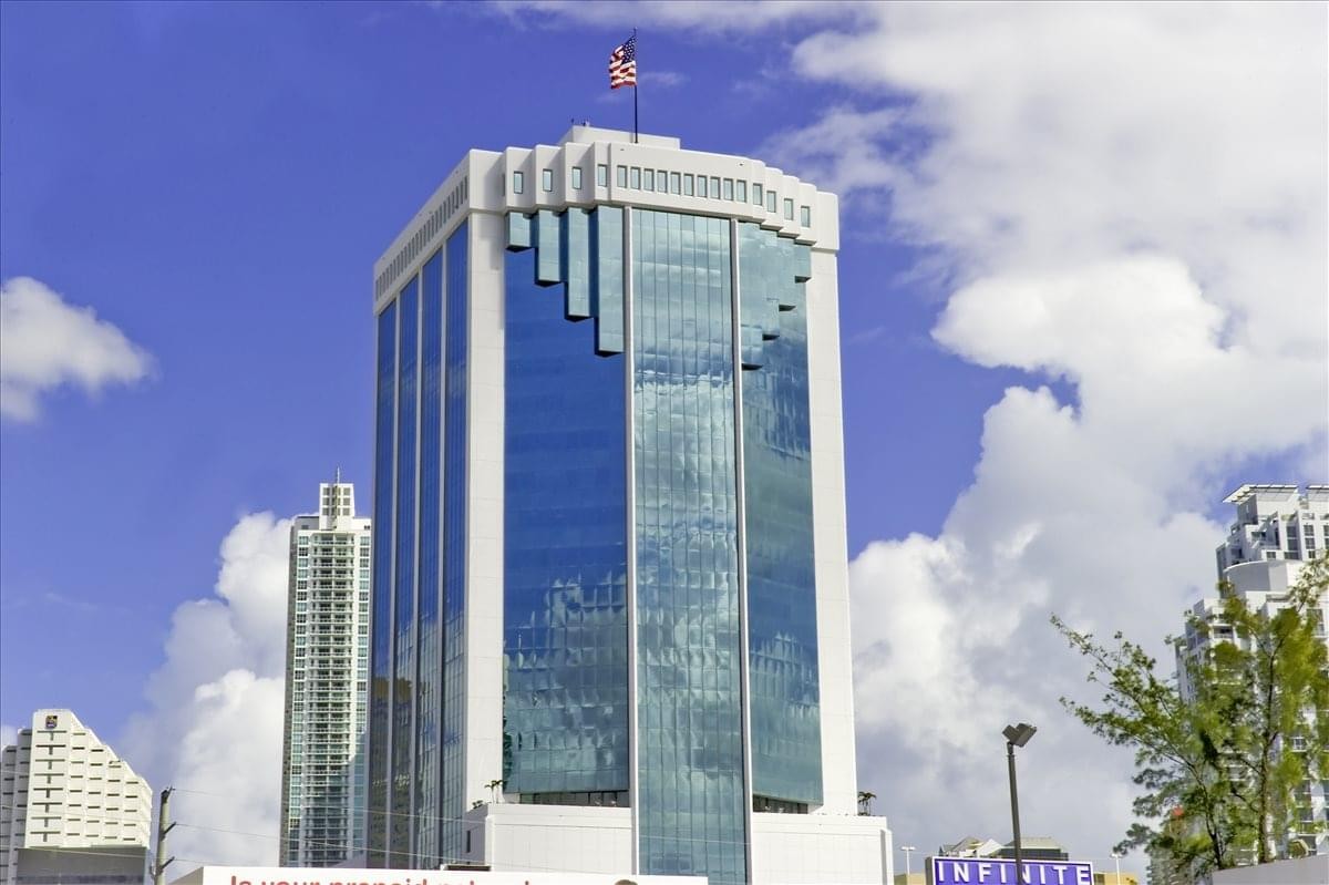 Exterior view of the blue-glass Brickell Bayview building with a tiered top.