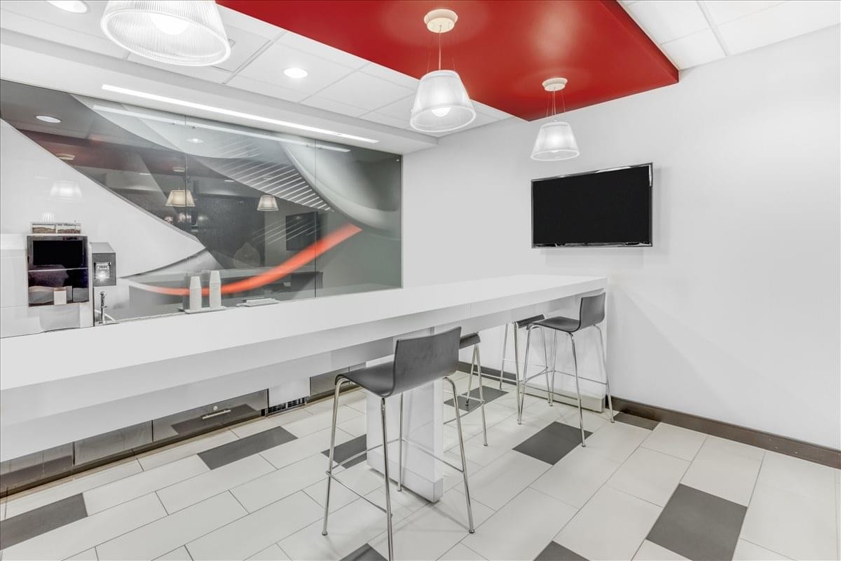 Modern break area at 800 S. Gay Street, Suite 700 with a long high-top table and red ceiling feature.