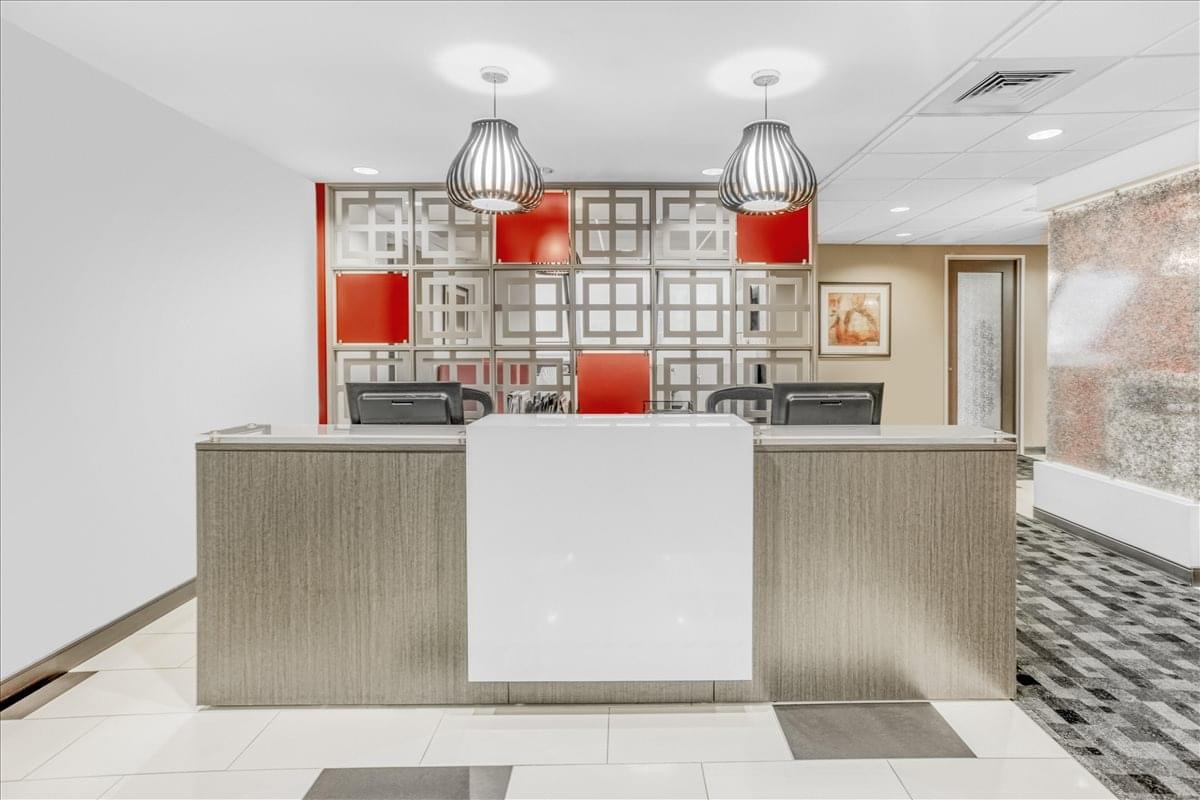 Modern reception desk at 800 S. Gay Street, Suite 700 with bright pendant lighting and red accents.