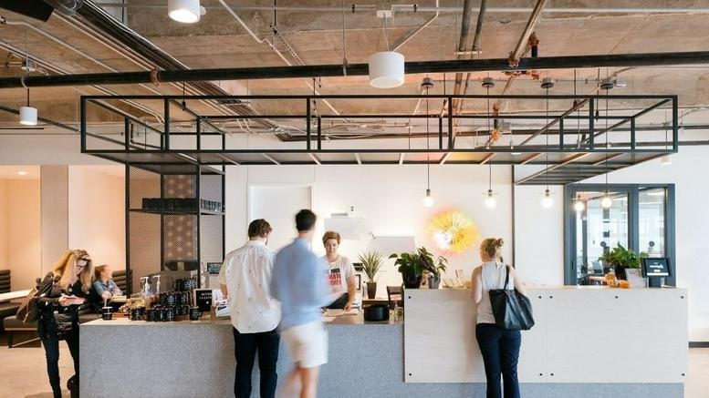 Spacious reception area and coffee bar at 801 Barton Springs with modern industrial design and pendant lighting.